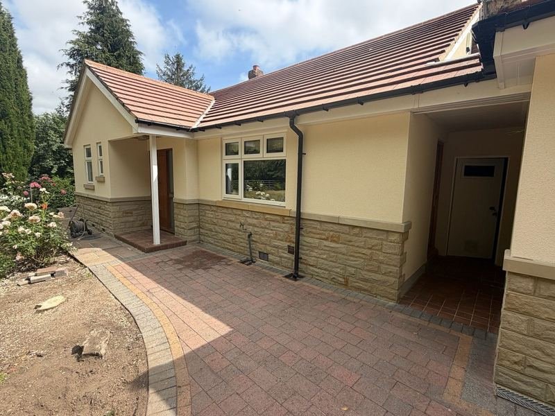 Side of the bungalow in Leeds LS28 after silicone render, with yorkshire stone cladding to the front